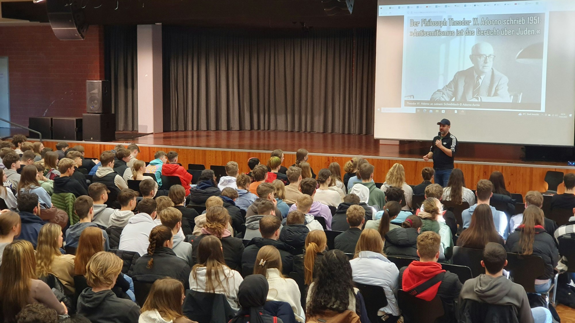 Ben Salomo steht in der Aula vor der Schülerschaft.