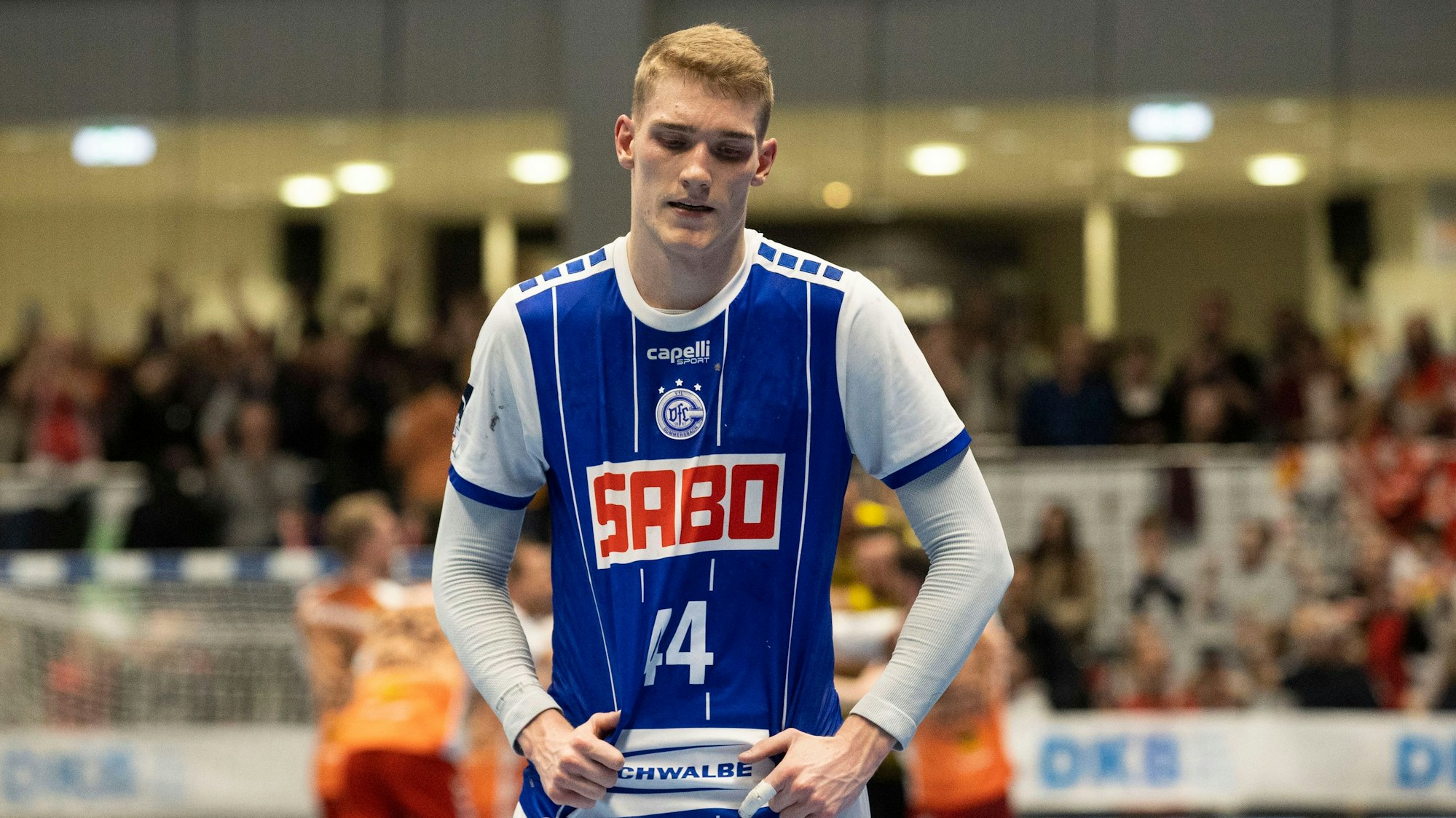 Zu sehen ist ein Handballspieler in einer Sporthalle.