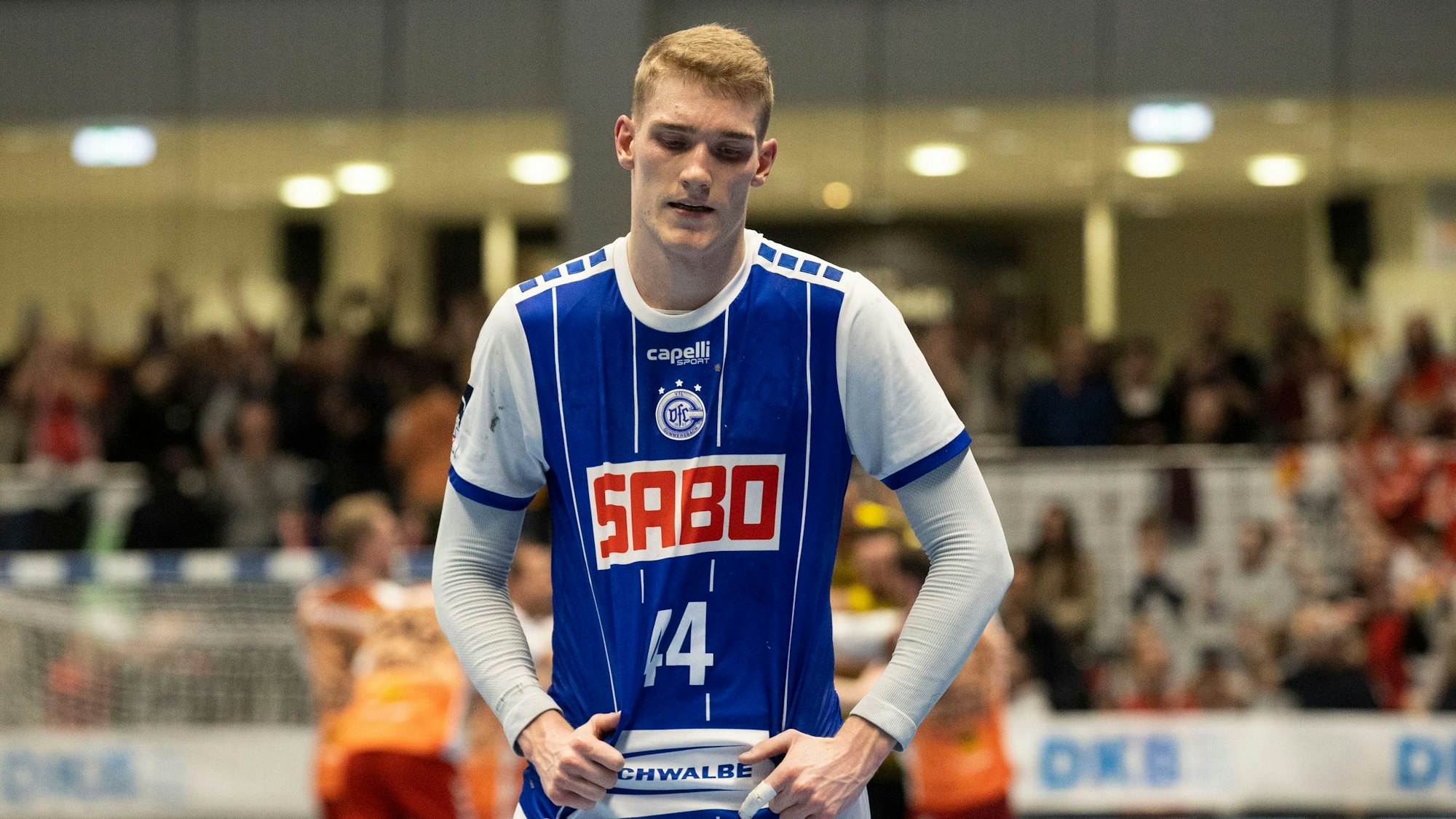 Zu sehen ist ein Handballspieler in einer Sporthalle.