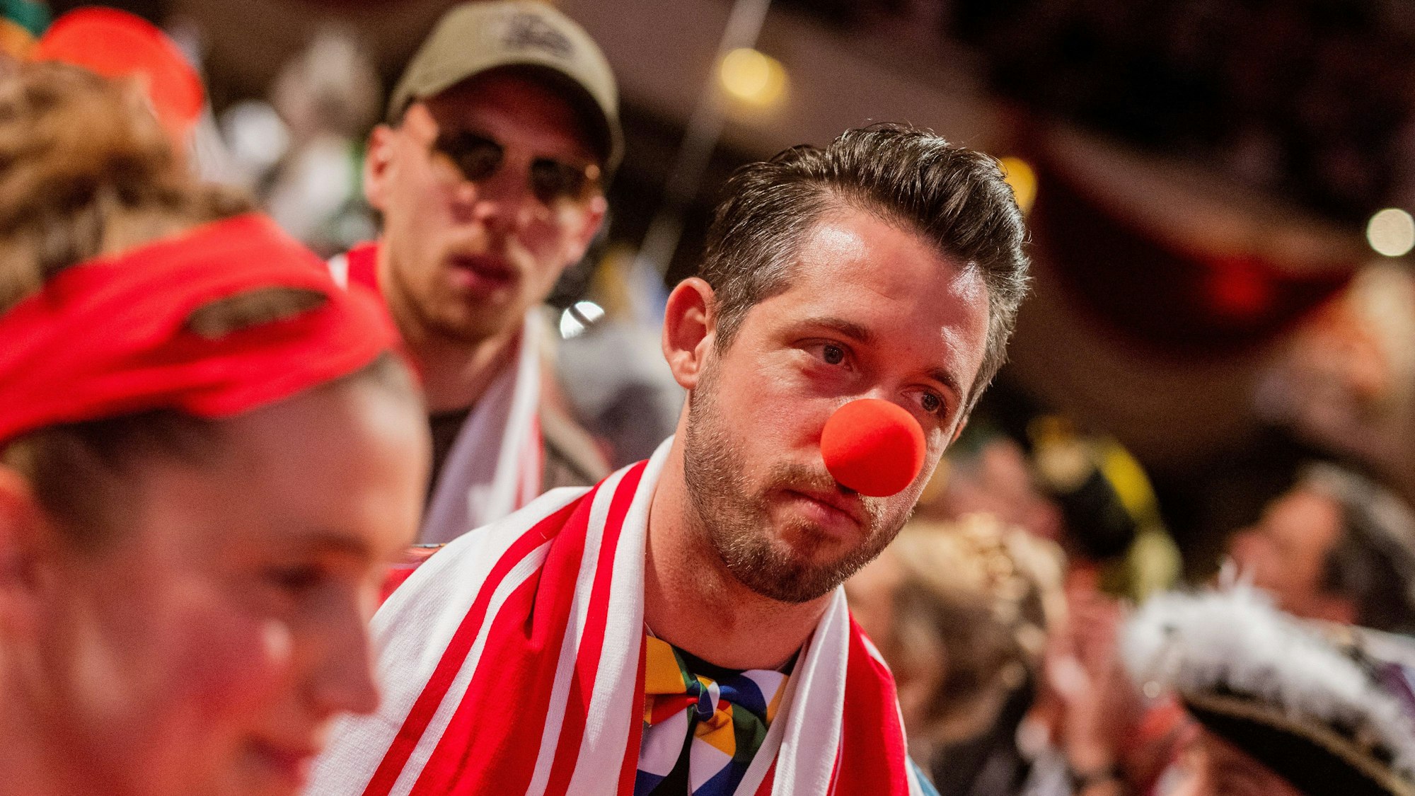 14.02.2023, Nordrhein-Westfalen, Köln: Mark Uth kommt mit Pappnase zur Karnevalssitzung des 1. FC Köln. Foto: Rolf Vennenbernd/dpa - WICHTIGER HINWEIS: Gemäß den Vorgaben der DFL Deutsche Fußball Liga bzw. des DFB Deutscher Fußball-Bund ist es untersagt, in dem Stadion und/oder vom Spiel angefertigte Fotoaufnahmen in Form von Sequenzbildern und/oder videoähnlichen Fotostrecken zu verwerten bzw. verwerten zu lassen. +++ dpa-Bildfunk +++