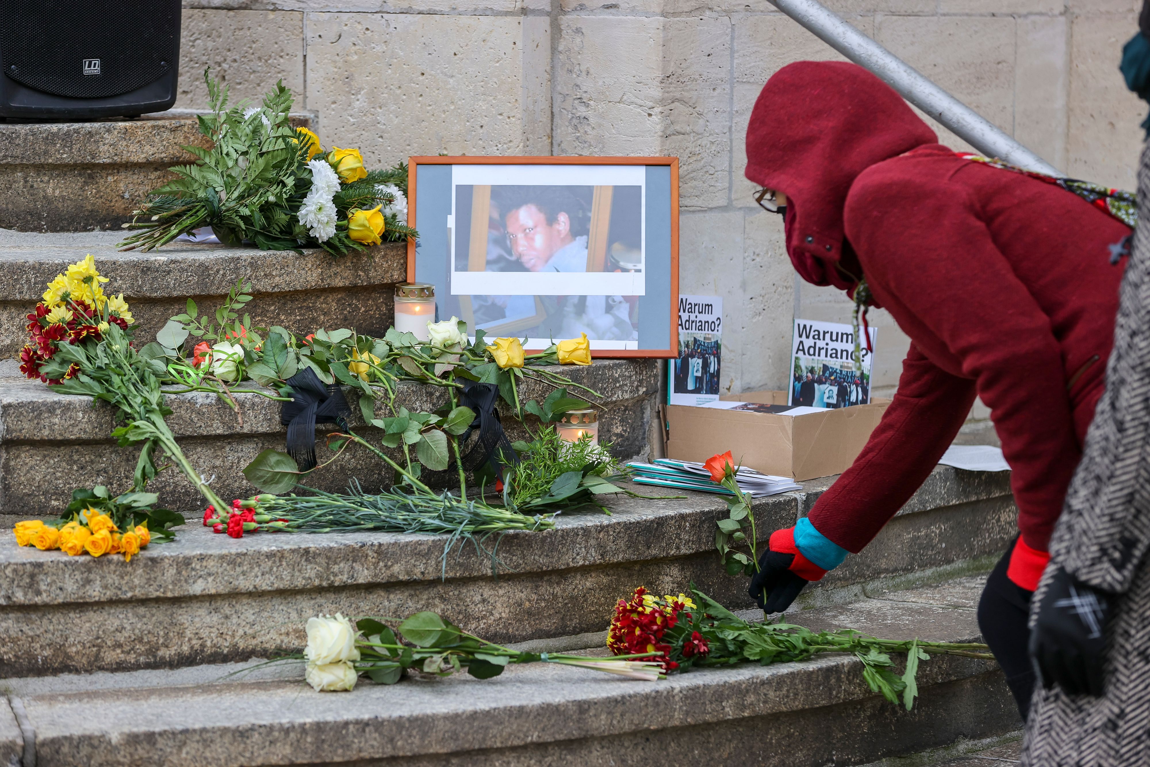 07.01.2022, Sachsen-Anhalt, Dessau-Roßlau: Eine Frau legt eine Rose zum Gedenken an den am 7. Januar 2005 in einer Gewahrsamszelle des Polizeireviers in Dessau-Roßlau ums Leben gekommenen Oury Jalloh auf die Stufen des Reviers.