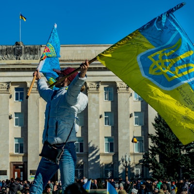 Eine Frau schwenkt eine ukrainische Flagge in der Nähe des Regierungsgebäudes von Cherson nach der Befreiung der Stadt durch die ukrainische Armee von der russischen Besatzung während des Krieges in der Ukraine. +++ dpa-Bildfunk +++