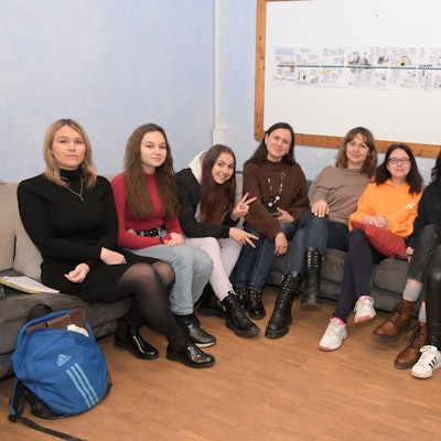 Ukrainerinnen sitzen auf einem Sofa in einem Klassenzimmer.