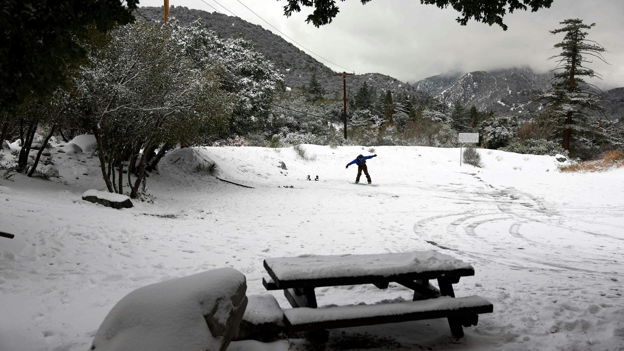 Eine Person fährt am 23. Februar 2023 in Mount Baldy, Kalifornien, auf einem Rastplatz in den San Gabriel Mountains in San Bernardino County nahe der östlichen Grenze zu Los Angeles County Snowboard.