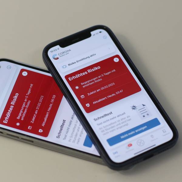 Die Kacheln in der Corona-Warn-App leuchten auf zwei Handys rot.