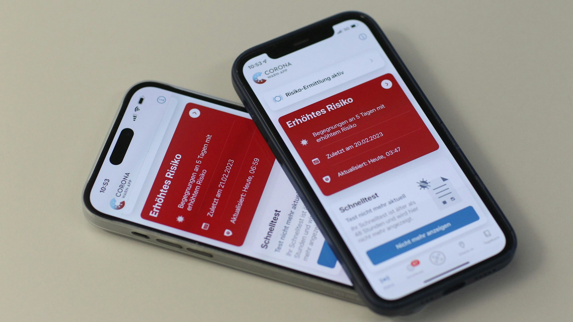 Die Kacheln in der Corona-Warn-App leuchten auf zwei Handys rot.