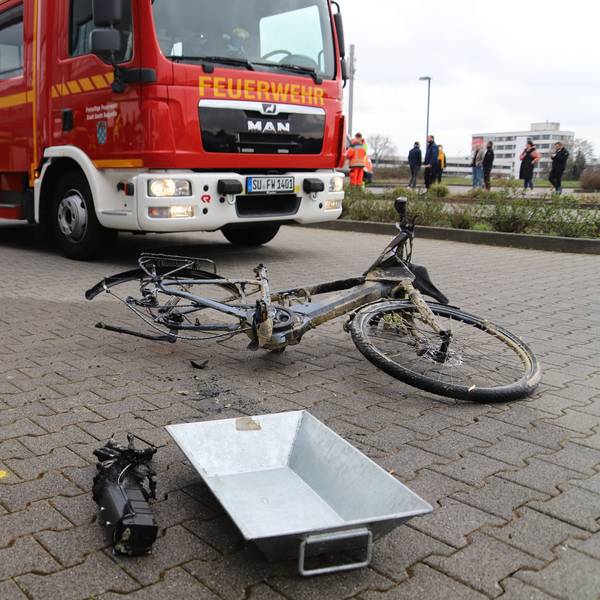 Ein kaputtes Pedelec liegt vor einem Einsatzwagen der Feuerwehr.
