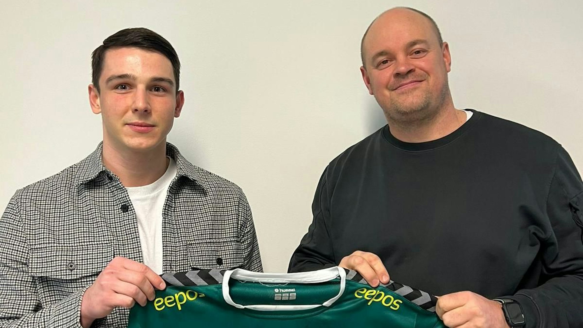 Zwei Männer stehen nebeneinander und halten gemeinsam ein Trikot des Handballvereins HC Gelpe/Strombach in der Hand mit der Nummer 33.