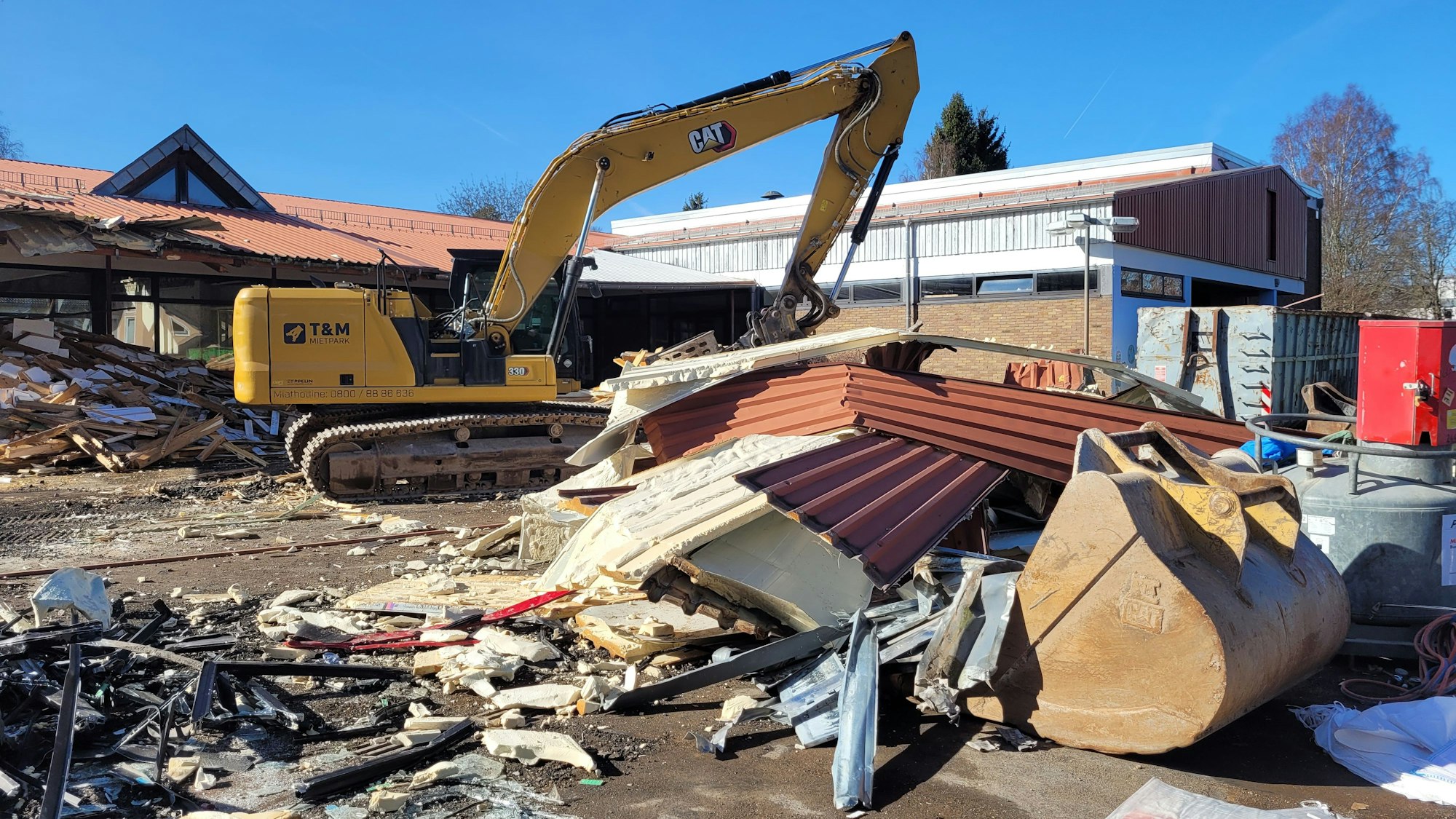 Ein Abrissbagger steht vor der früheren Grundschule in Kall.