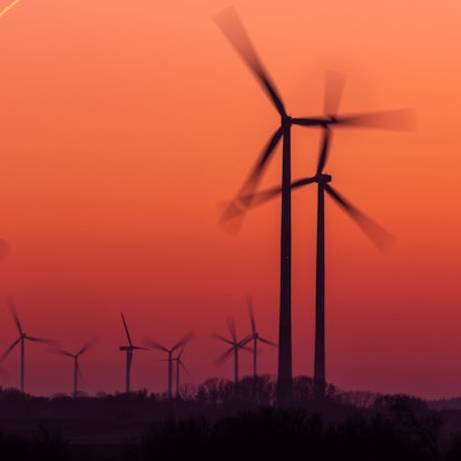 Die Rotoren von Windkraftanlagen drehen sich nach Sonnenuntergang.