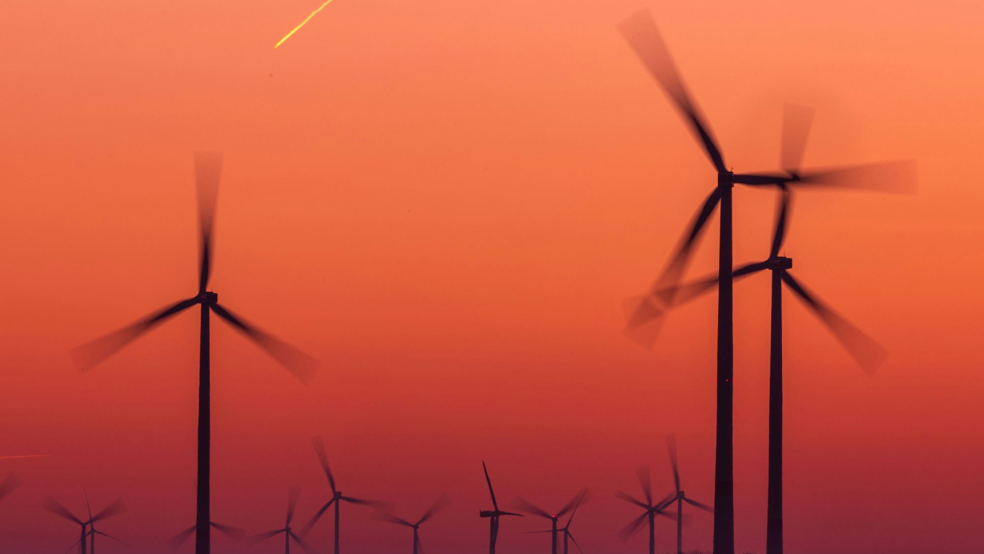 Die Rotoren von Windkraftanlagen drehen sich nach Sonnenuntergang.