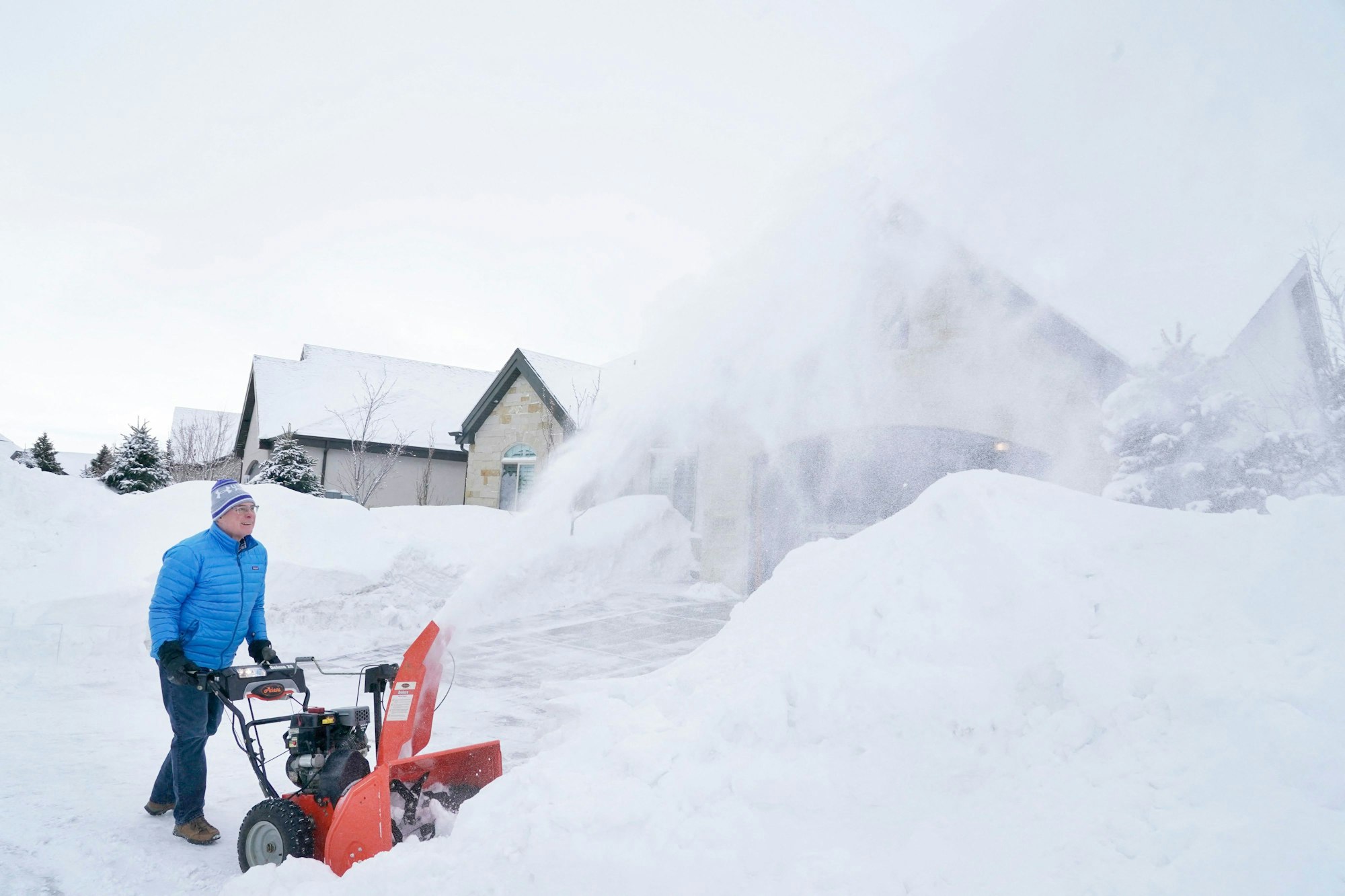 Ein Mann räumt am 23. Februar 2023 in Draper, Utah, meterweise Schnee von der Einfahrt seines Hauses.