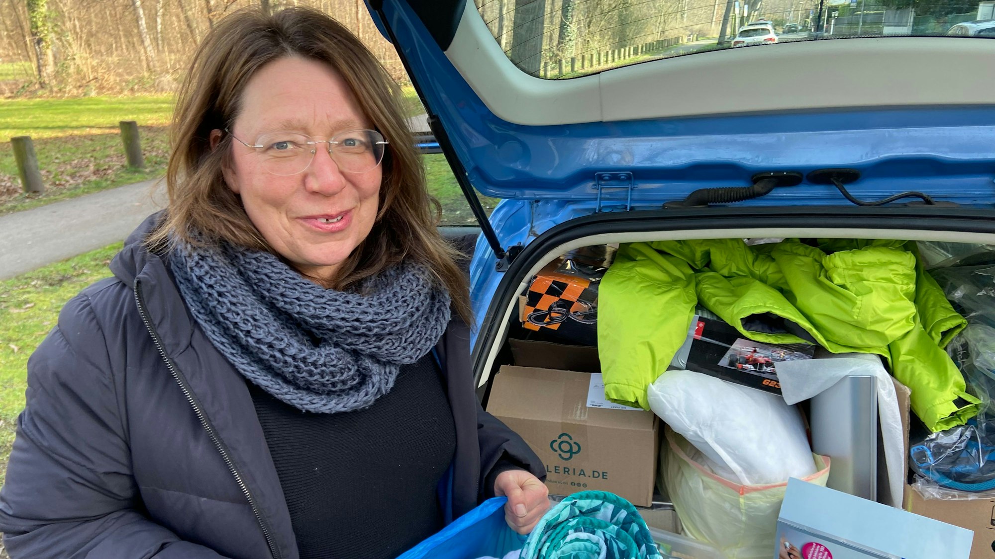 Sabine Frömel steht vor dem Kofferaum eines voll bepackten Autos