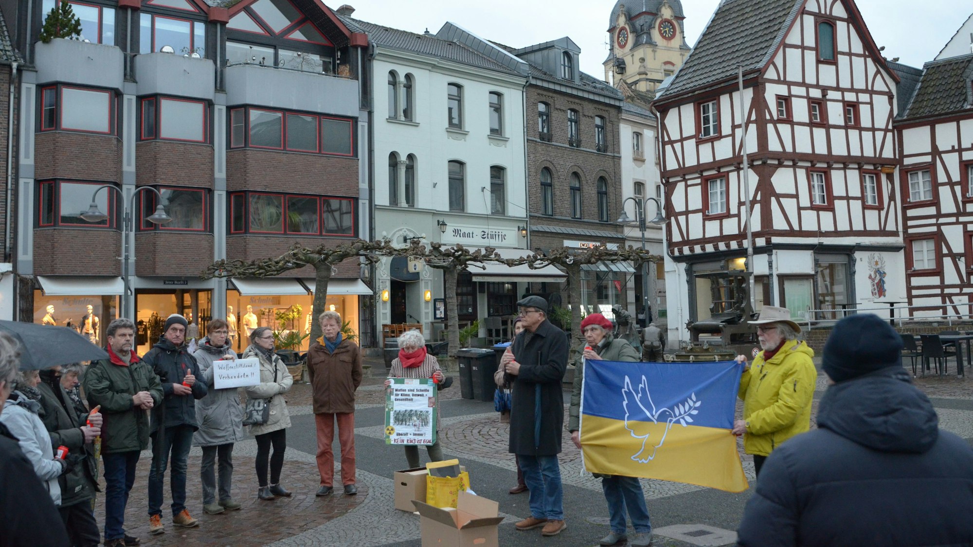 Mehrere Menschen gedenken der Opfer des Ukraine-Kriegs.