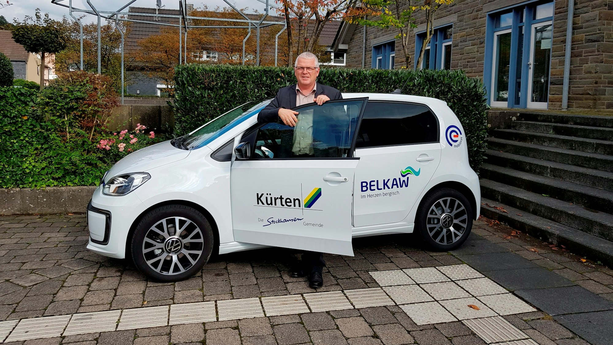 Bürgermeister Willi Heider steigt in ein E-Auto der Verwaltung.