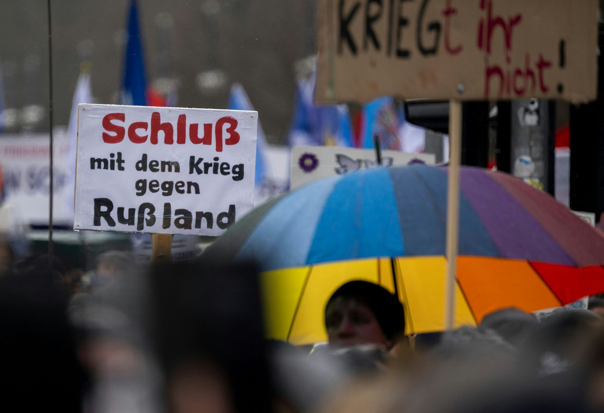 Ein Teilnehmer der Demonstration hält einen Schild mit der Aufschrift „Schluß mit dem Krieg gegen Rußland“ hoch.