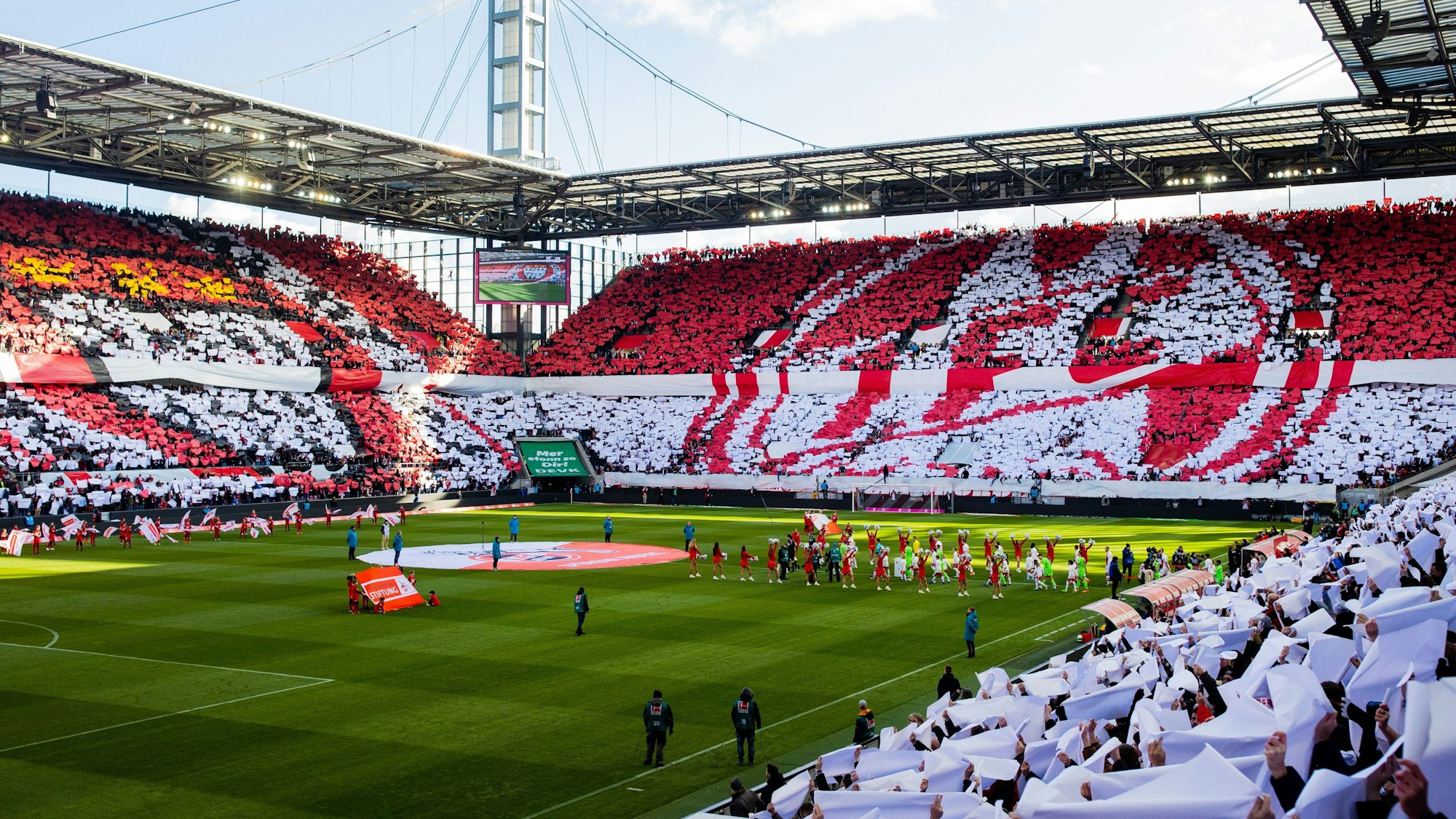 25.02.2023, Nordrhein-Westfalen, Köln: Fußball: Bundesliga, 1. FC Köln - VfL Wolfsburg, 22. Spieltag, RheinEnergieStadion. Das ganze Stadion zeigt zum 75-jährigen Jubliäum des 1. FC eine Choreografie. Foto: Rolf Vennenbernd/dpa - WICHTIGER HINWEIS: Gemäß den Vorgaben der DFL Deutsche Fußball Liga bzw. des DFB Deutscher Fußball-Bund ist es untersagt, in dem Stadion und/oder vom Spiel angefertigte Fotoaufnahmen in Form von Sequenzbildern und/oder videoähnlichen Fotostrecken zu verwerten bzw. verwerten zu lassen. +++ dpa-Bildfunk +++