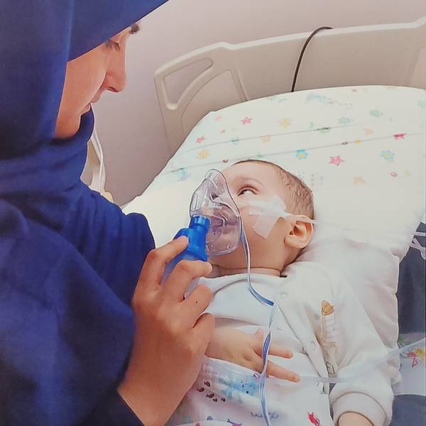Nuran Atak hält am Bett ihres Kindes die Sauerstoffmaske, mit der der elf Monate alte Junge künstlich beatmet wird.