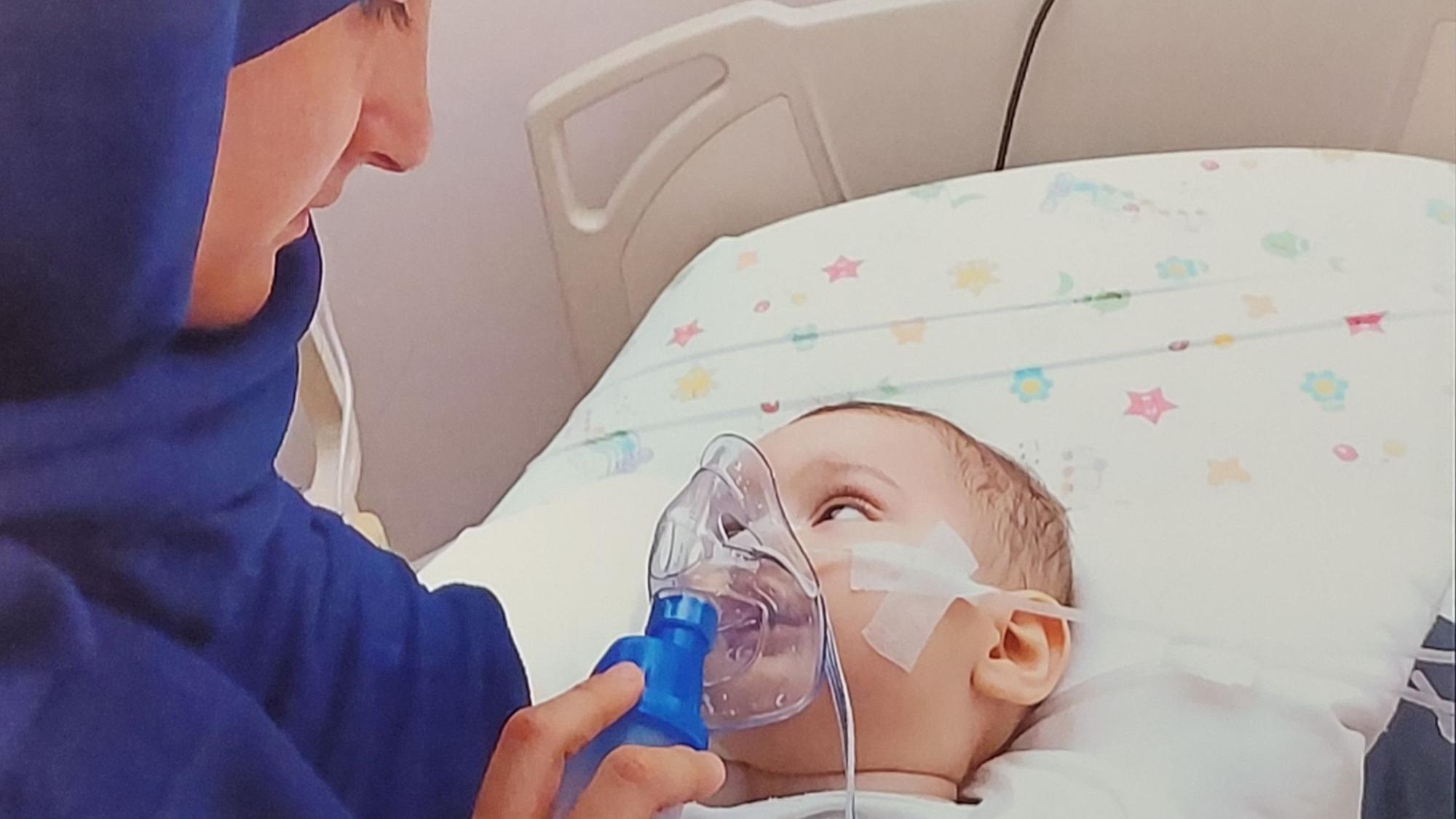 Nuran Atak hält am Bett ihres Kindes die Sauerstoffmaske, mit der der elf Monate alte Junge künstlich beatmet wird.