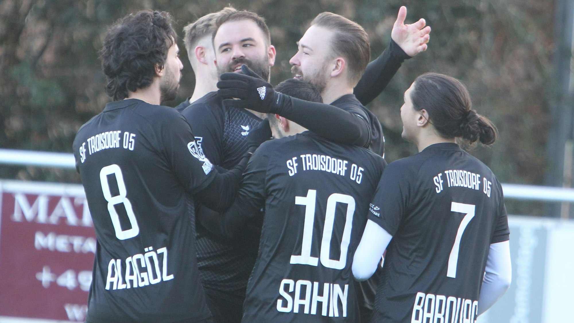 Torschütze Marcel Wiemer lächelt und nimmt die Glückwünsche seiner Teamkollegen mit offenen Armen entgegen.