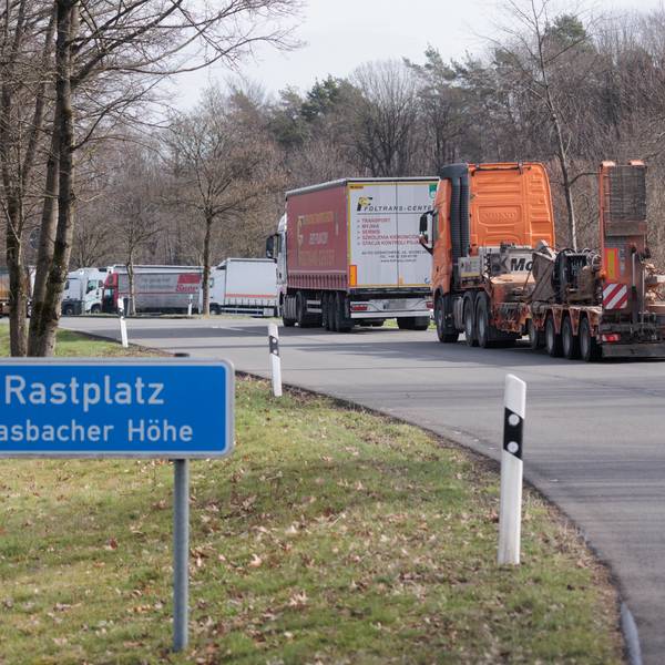 Blick auf eine Kolonne von Lkws auf einem Autobahnrastplatz
