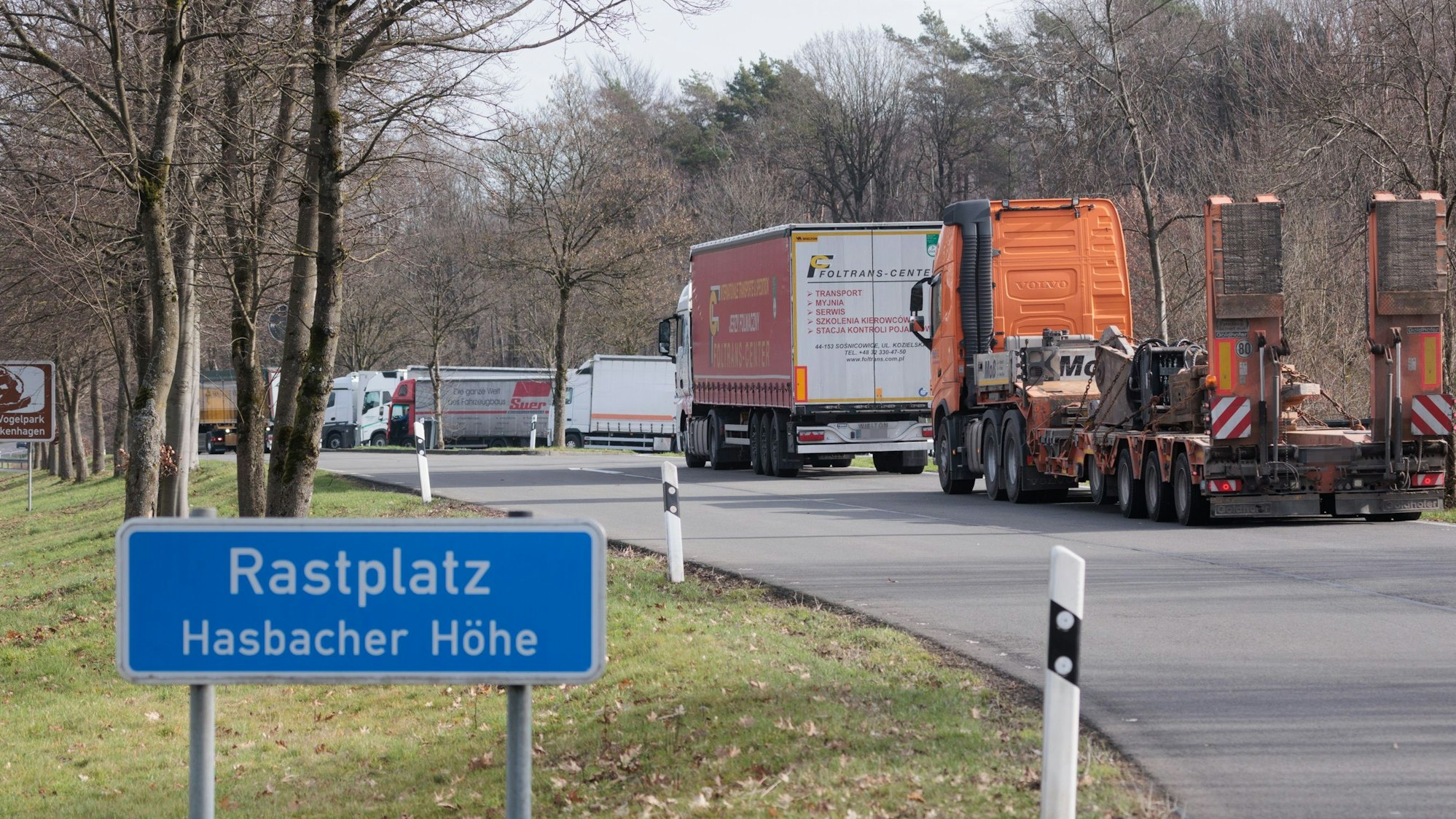 Blick auf eine Kolonne von Lkws auf einem Autobahnrastplatz