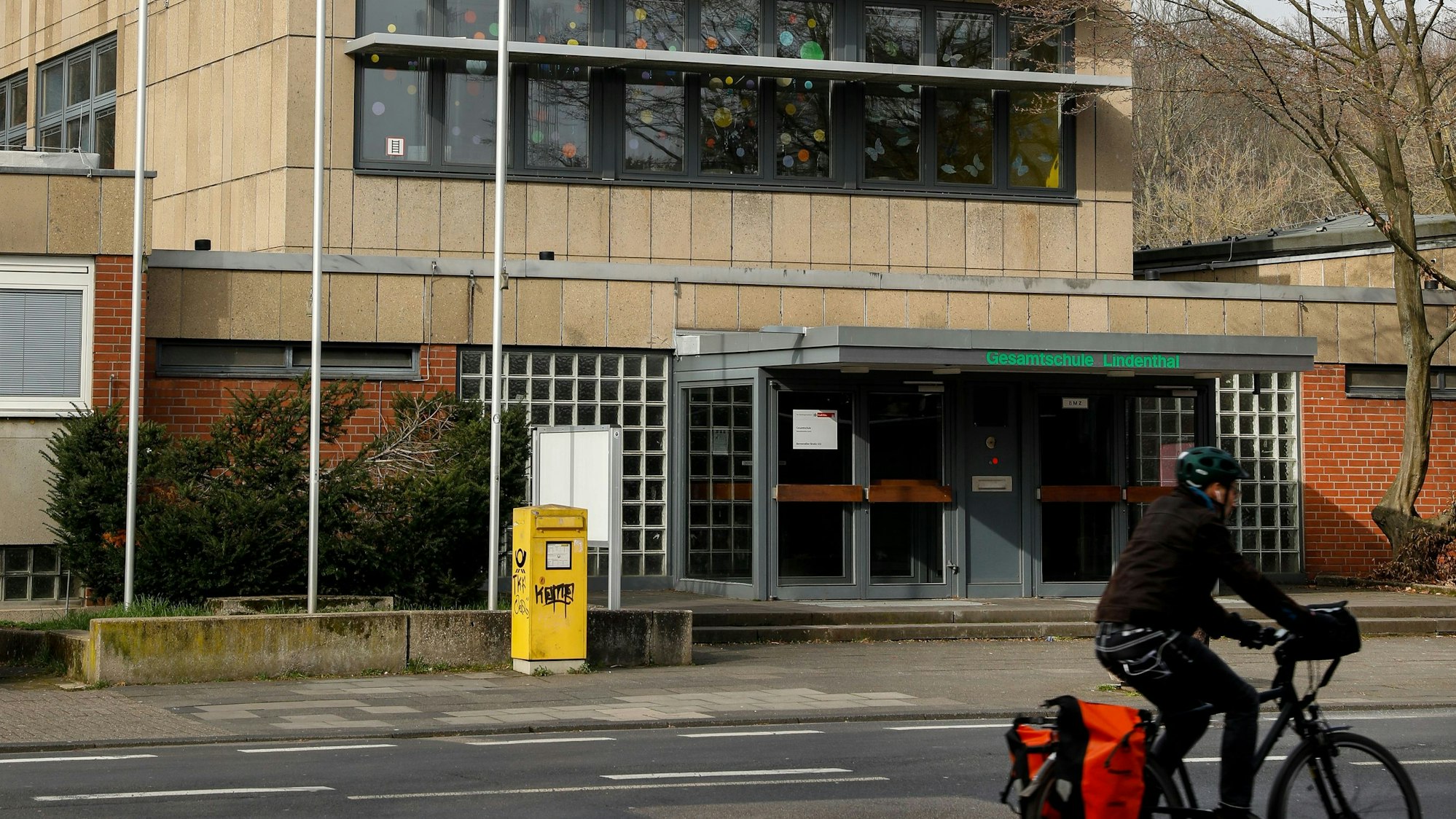 Ein Schulgebäude steht an einer Straße.