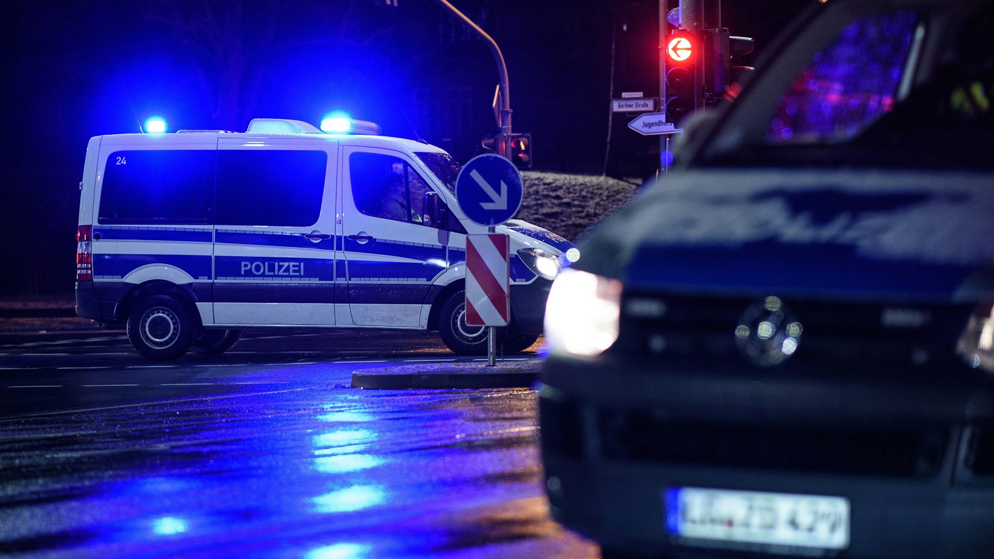 Einsatzfahrzeuge der Polizei sperren einen Einsatzort. Bei dem Wagen im Hintergrund ist das Blaulicht eingeschaltet. (Symbolbild)