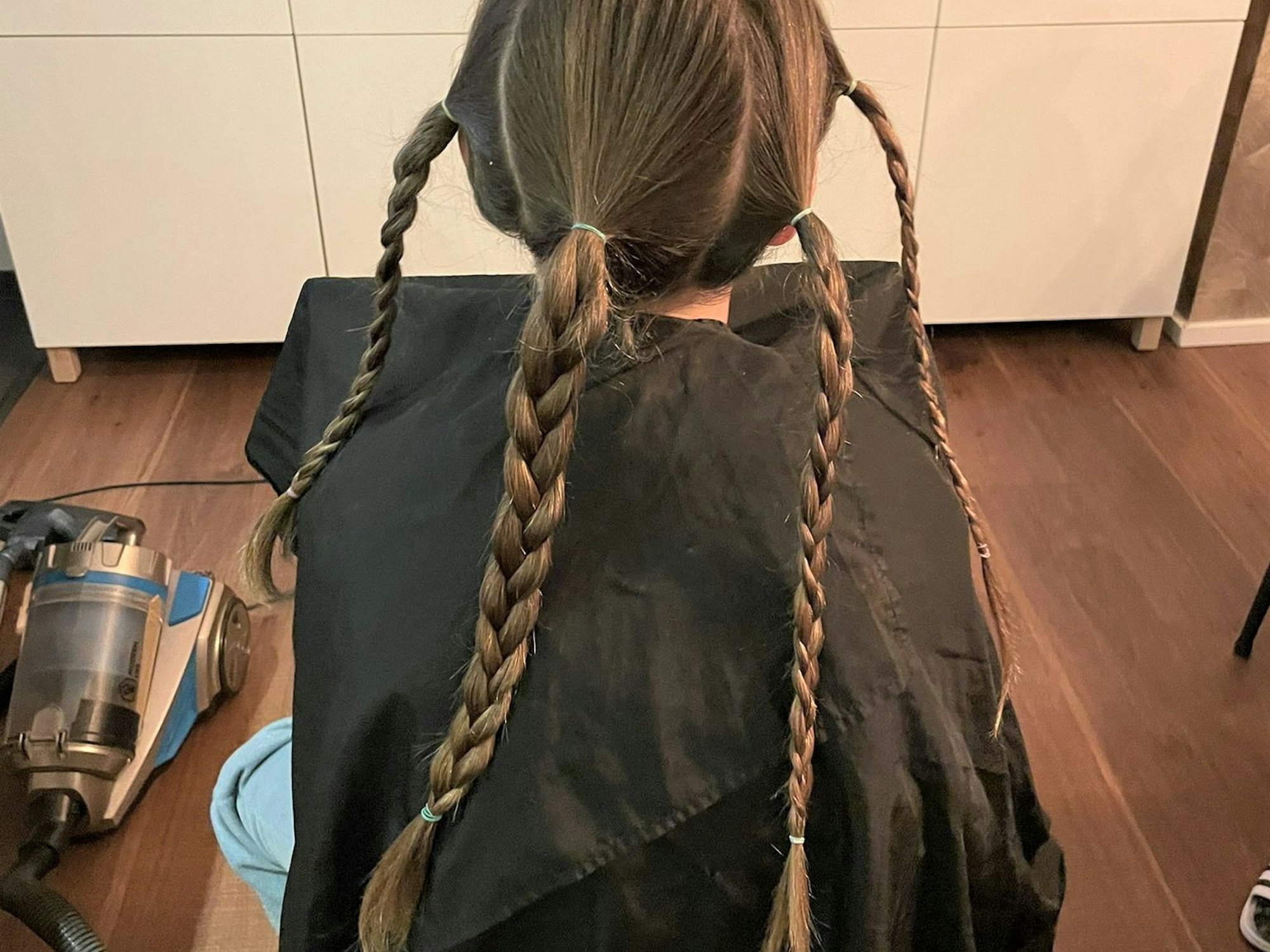 Die Haare sind zu mehreren Zöpfen geflochten.