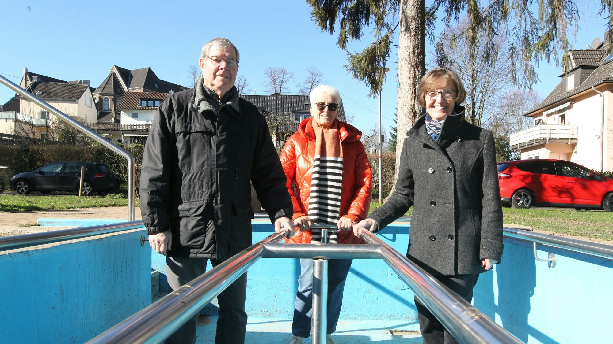 Der Vereinsvorsitzende, seine Stellvertreterin Hilde Litterscheid und Kassiererin stehen in einem leeren Becken.