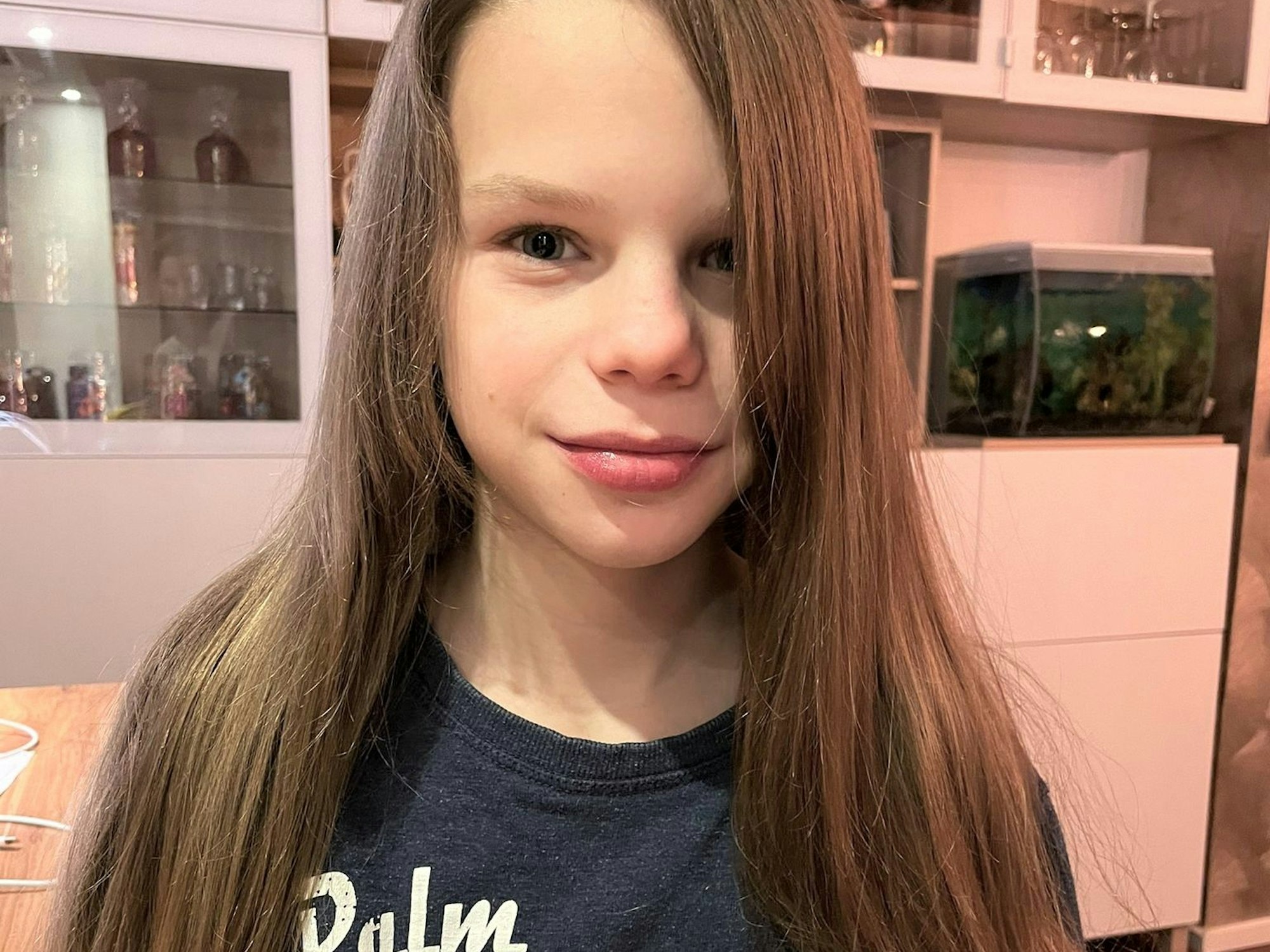 Er steht mit seinen offenen langen Haaren zur Kamera gerichtet.