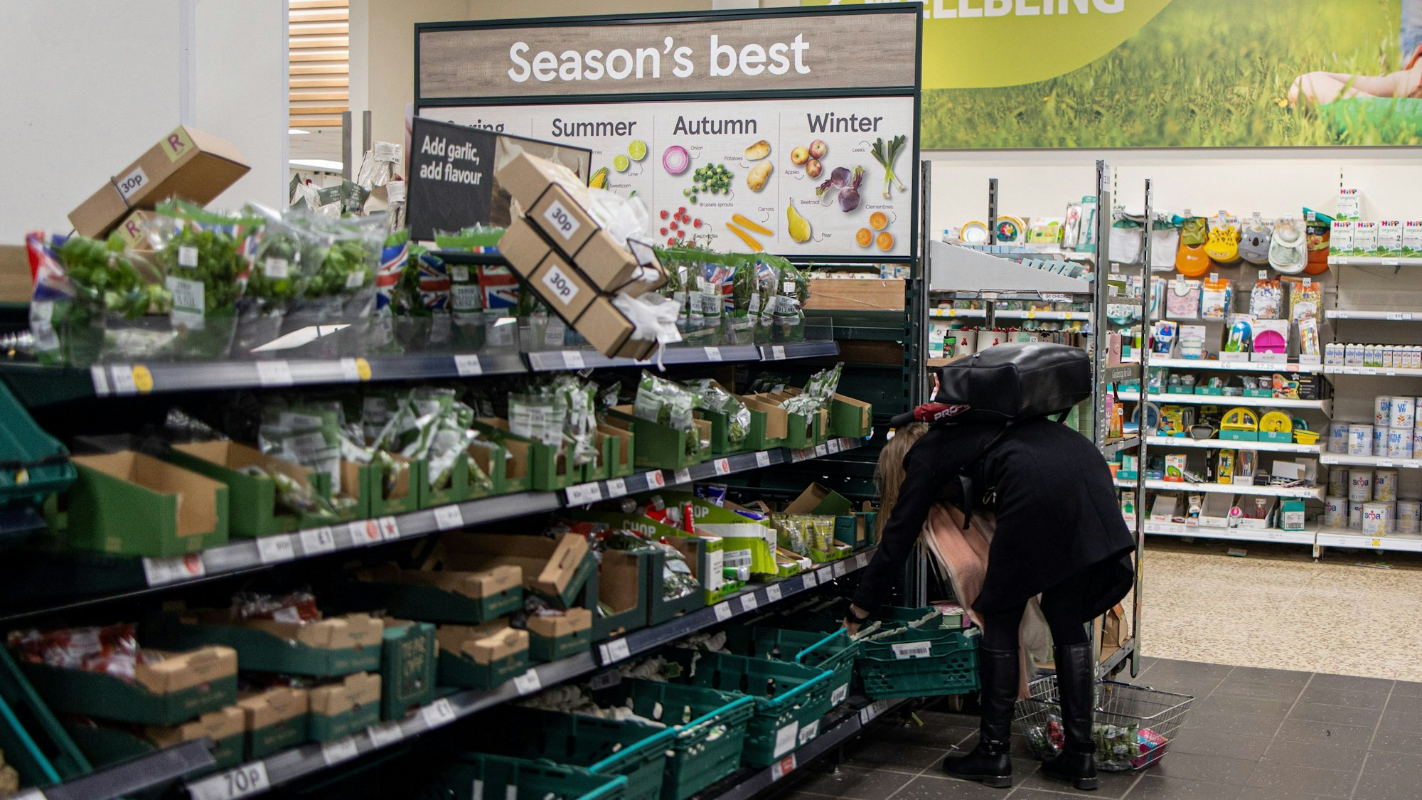 Eine Kundin versucht, in einem Tesco-Supermarkt in London die letzte Tüte mit frischem Gemüse im Korb zu finden.