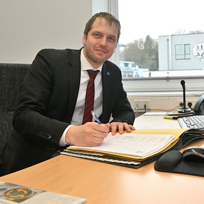 Mario Bredow sitzt an seinem Schreibtisch.