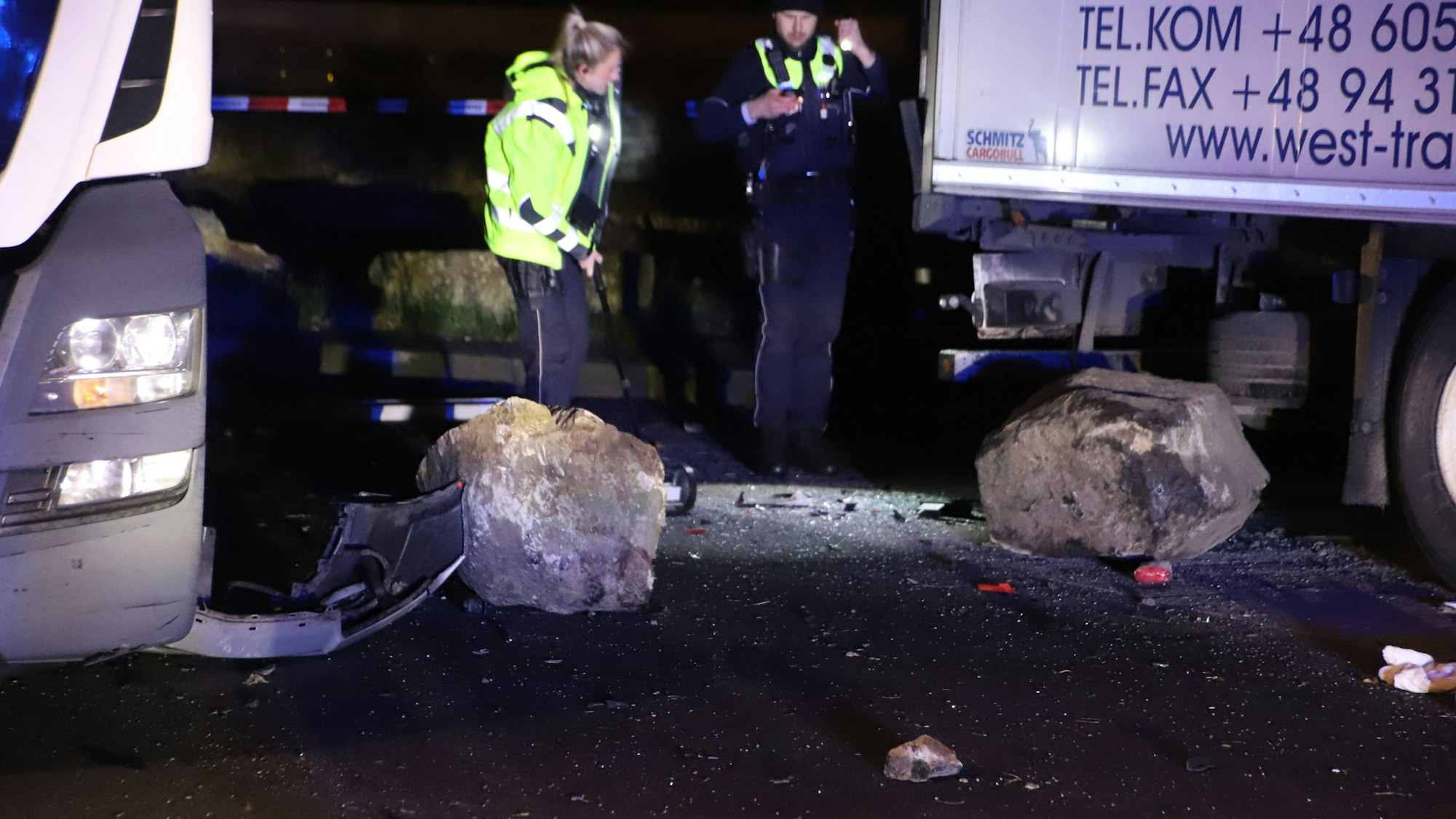 Zwei große Felsbrocken liegen auf der Straße, beide etwa so groß wie Autoreifen.