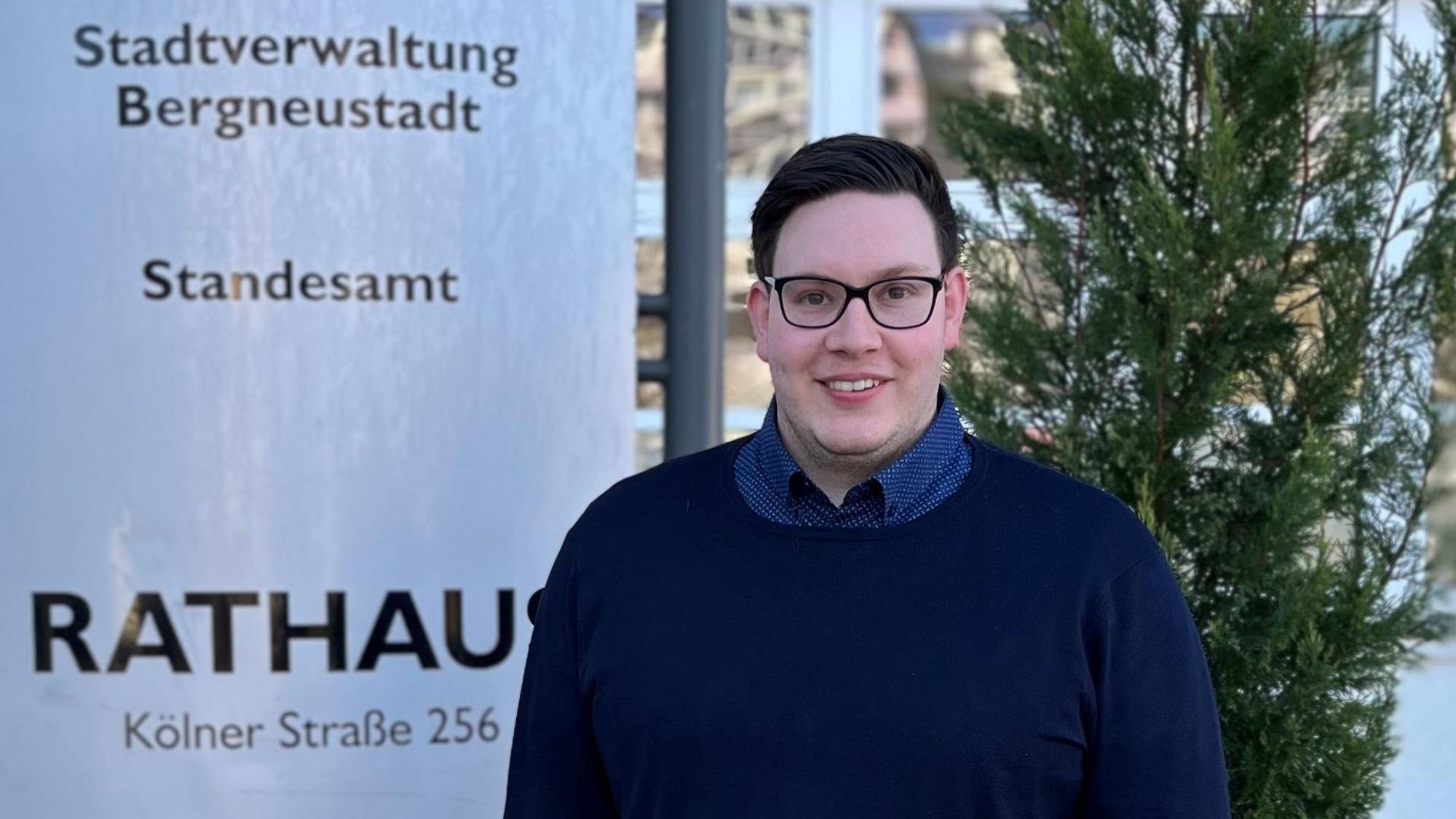 Ein junger Mann steht vor dem Rathaus in Bergneustadt.