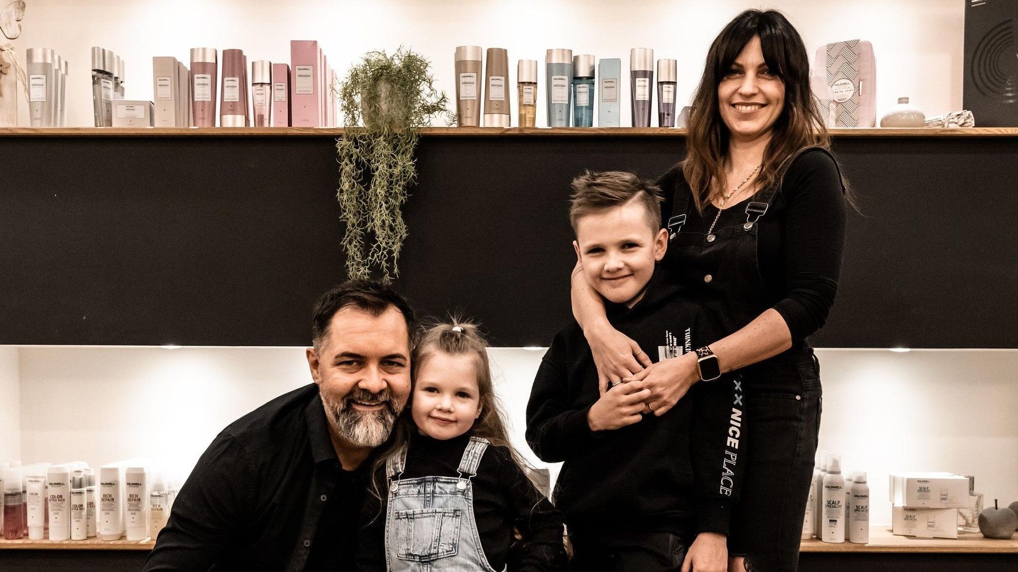Die Familie steht im Friseursalon.