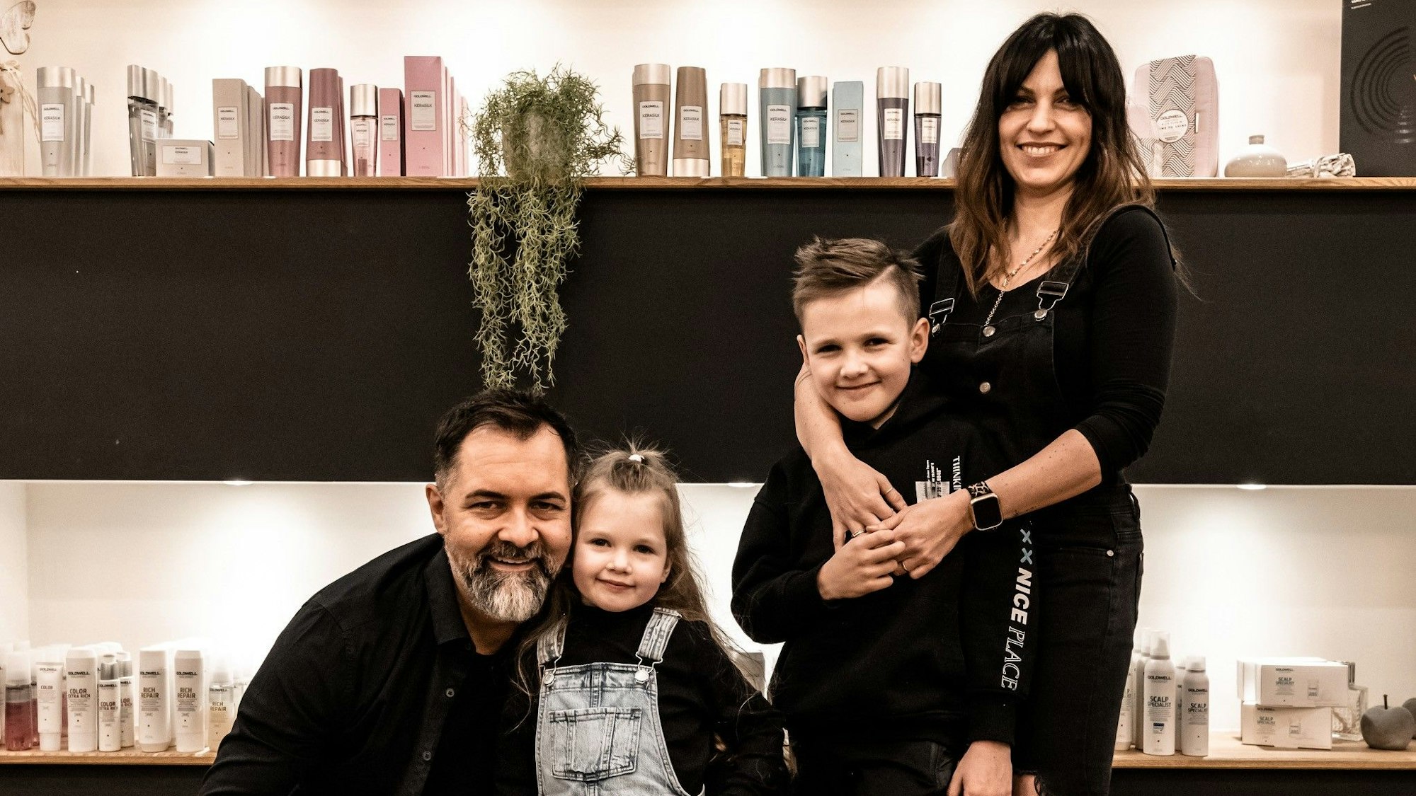 Die Familie steht im Friseursalon.