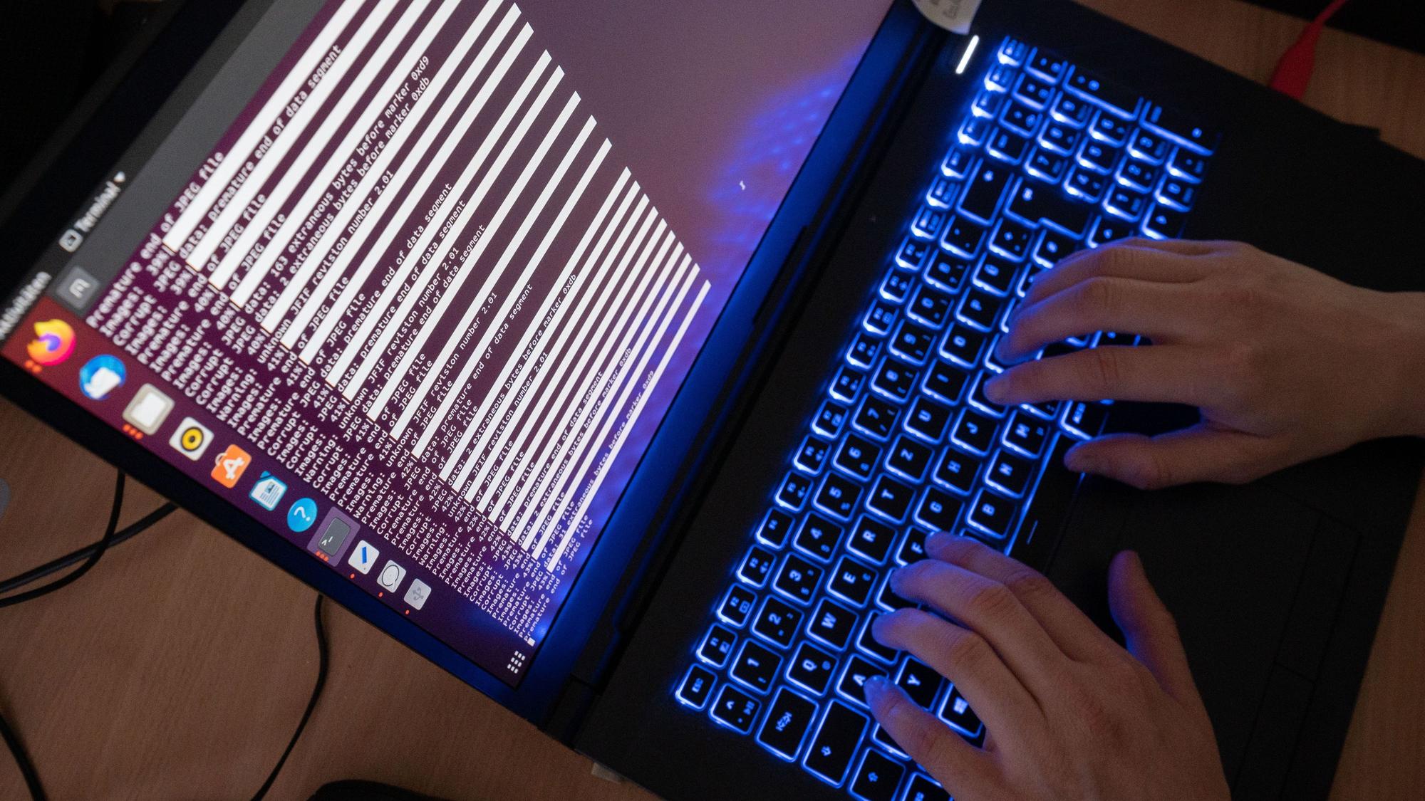 Eine Frau tippt auf der Tastatur eines Laptops.