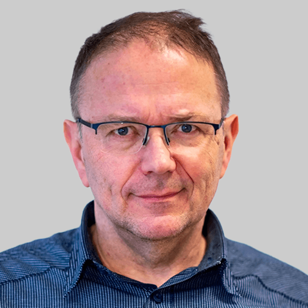 Eine Schülerin hält einen Menstruationsartikel vor einem Menstruationsartikel-Spender.