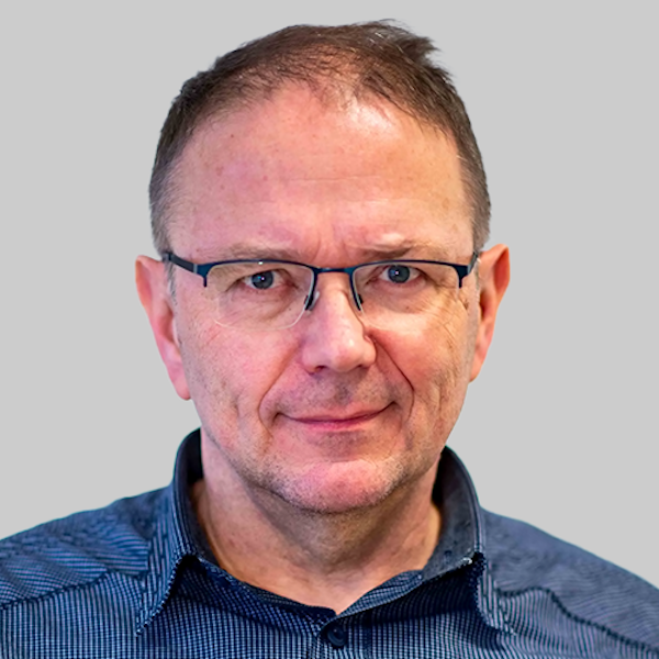 Eine Schülerin hält einen Menstruationsartikel vor einem Menstruationsartikel-Spender.