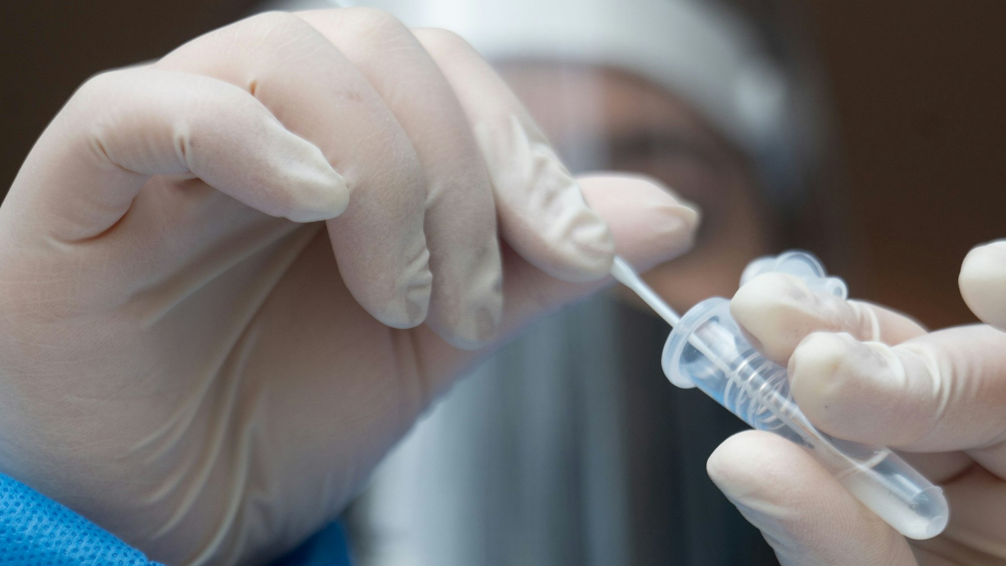 Eine Mitarbeiterin führt in einer Teststation in einer Apotheke einen Antigen-Schnelltest durch.