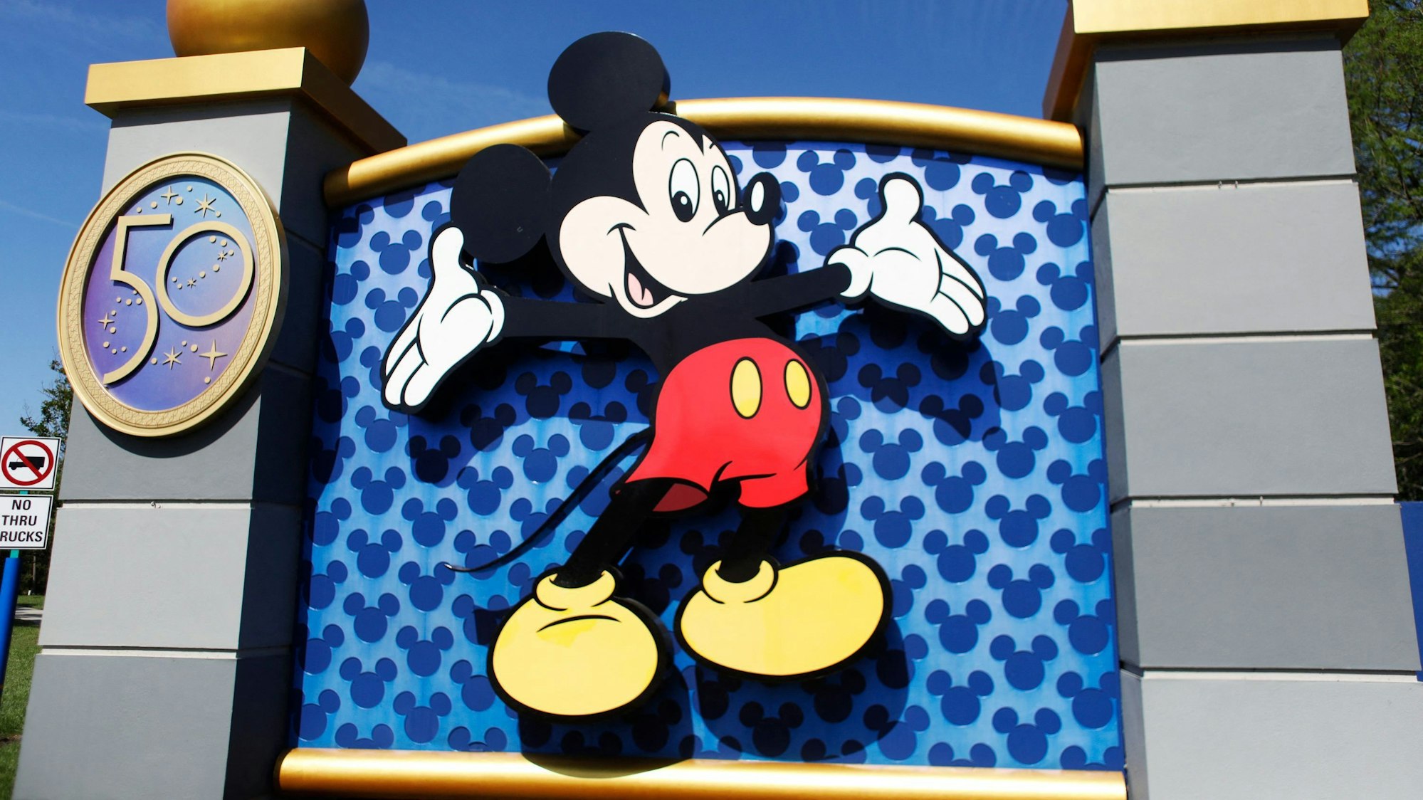 Das Foto zeigt den Eingangsbereich des Disney World Themenparks in Orlando, Florida. Das Abbild Micky Maus prangt auf dem großen Tor.