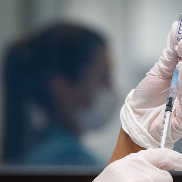 Eine Frau zieht eine Dosis des Impfstoffes von Biontech/Pfizer für eine Corona-Impfung auf.