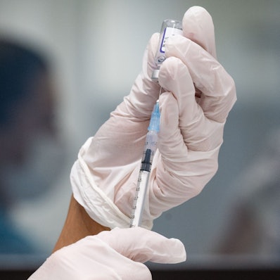 Eine Frau zieht eine Dosis des Impfstoffes von Biontech/Pfizer für eine Corona-Impfung auf.