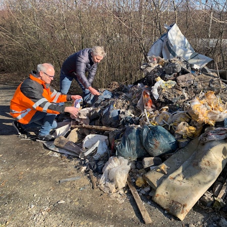 Eine ganze Wagenladung voller Bauschutt kombiniert mit Hausmüll liegt auf der Straße.
