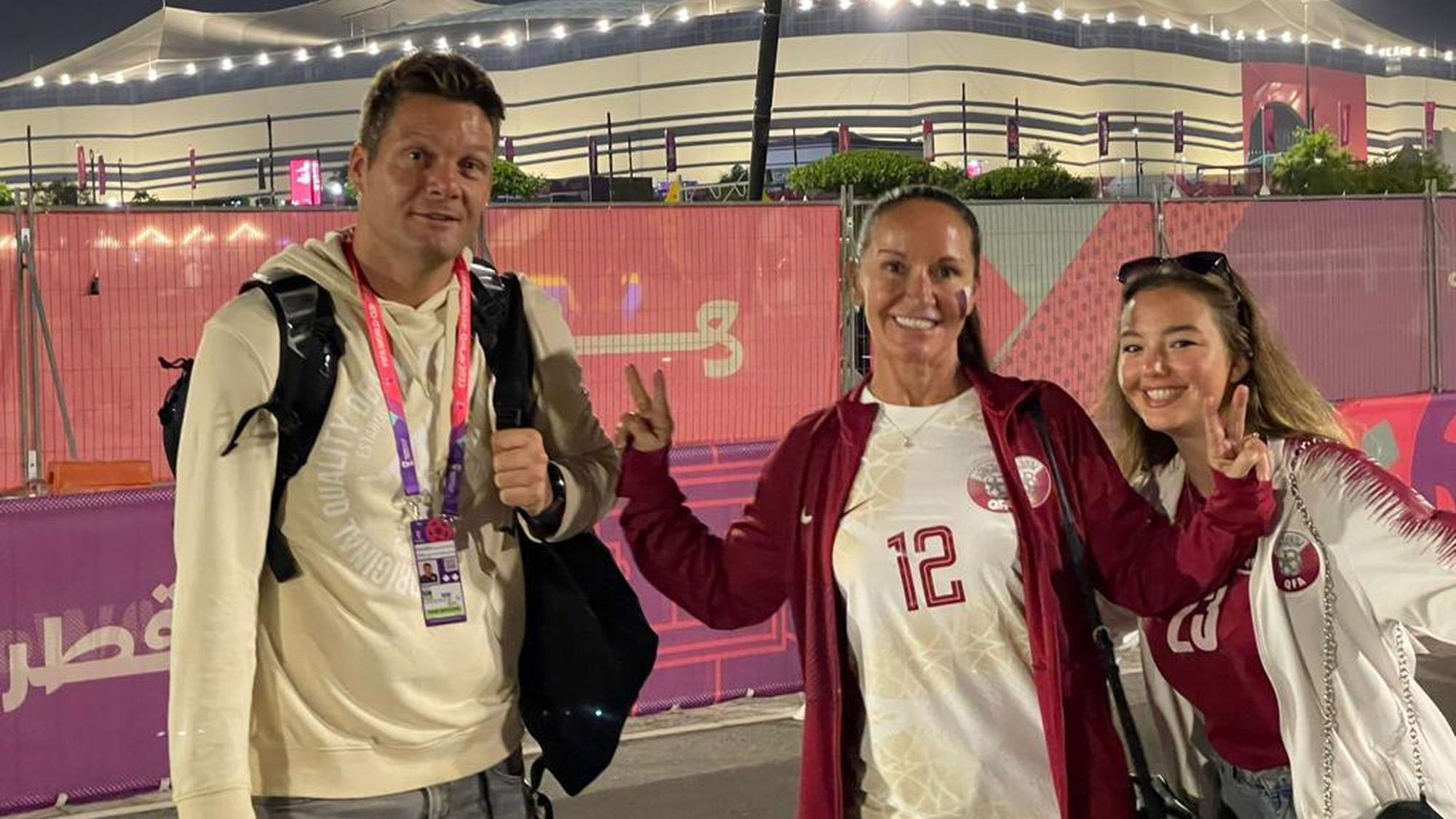 Julius Büscher und Familie stehen gemeinsam vor einem beleuchteten Stadion.