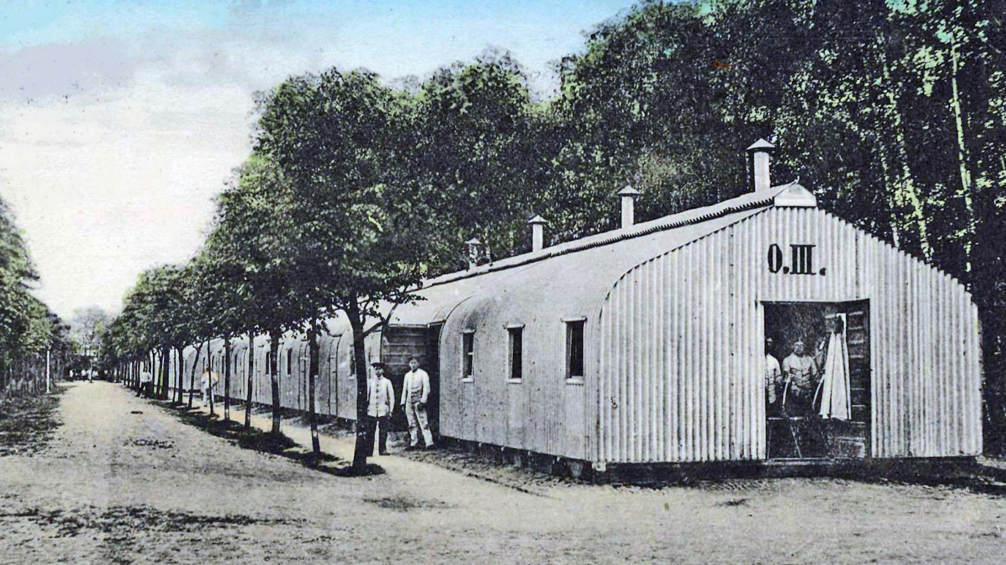 Blick auf eine ältere Zeichnung von Baracken, die zwischen Bäumen stehen.