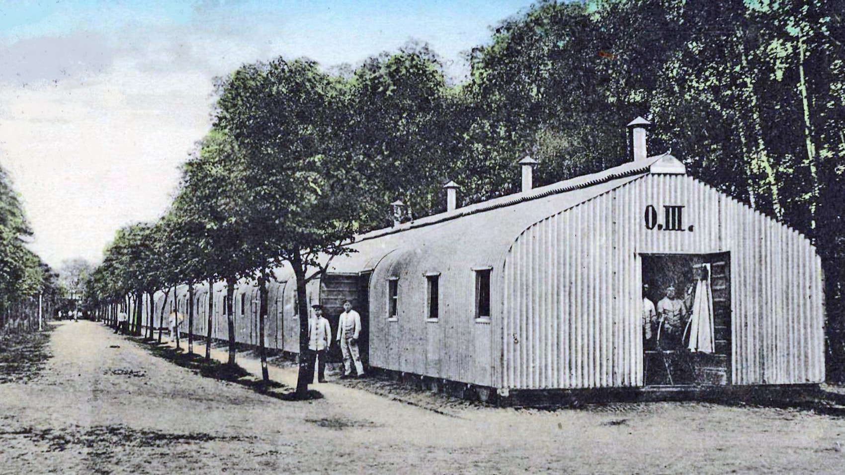 Blick auf eine ältere Zeichnung von Baracken, die zwischen Bäumen stehen.
