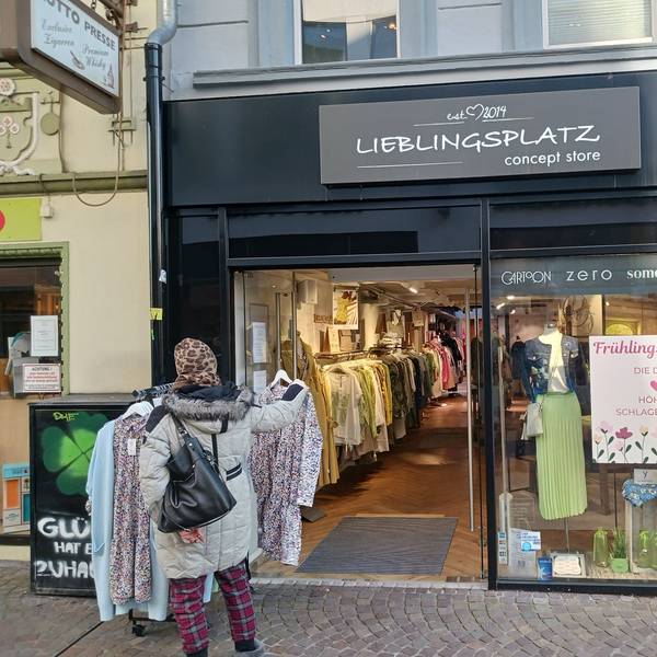 Eine Frau steht vor einem Modegeschäft.