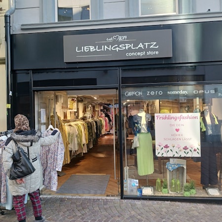 Eine Frau steht vor einem Modegeschäft.